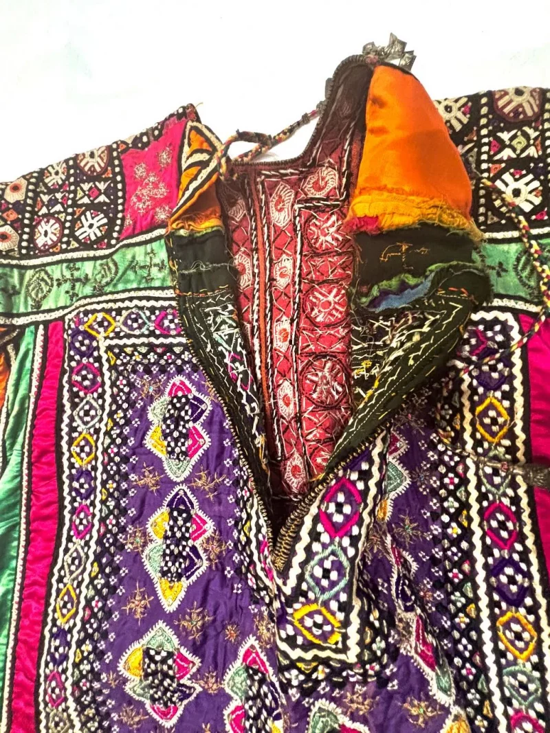 Interior view of a Baluchi embroidered garment showing colorful decorative panels and traditional needlework
