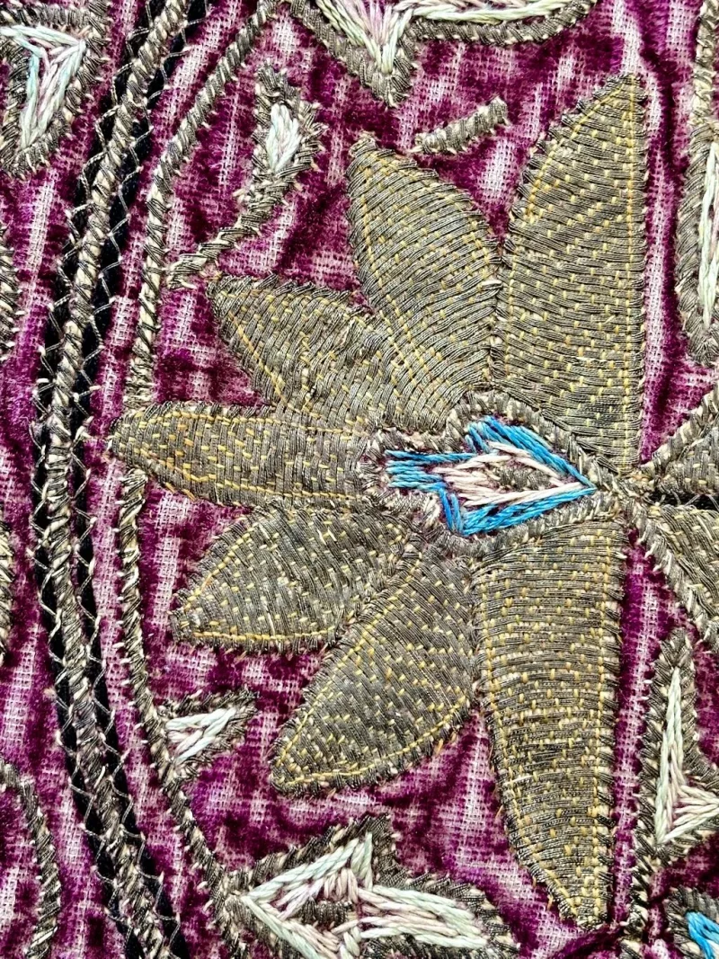 Persian metal thread embroidery showing couched metallic threads forming a floral design